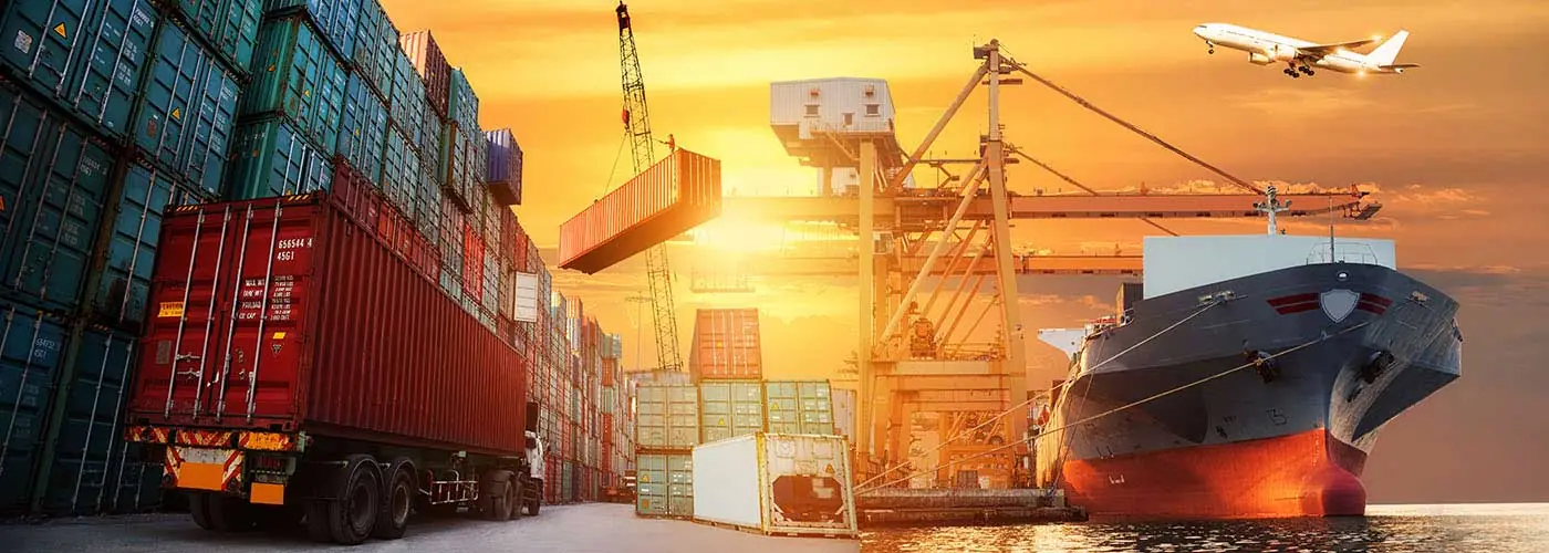 Container terminal at sunset with a cargo ship, container trailer and aircraft